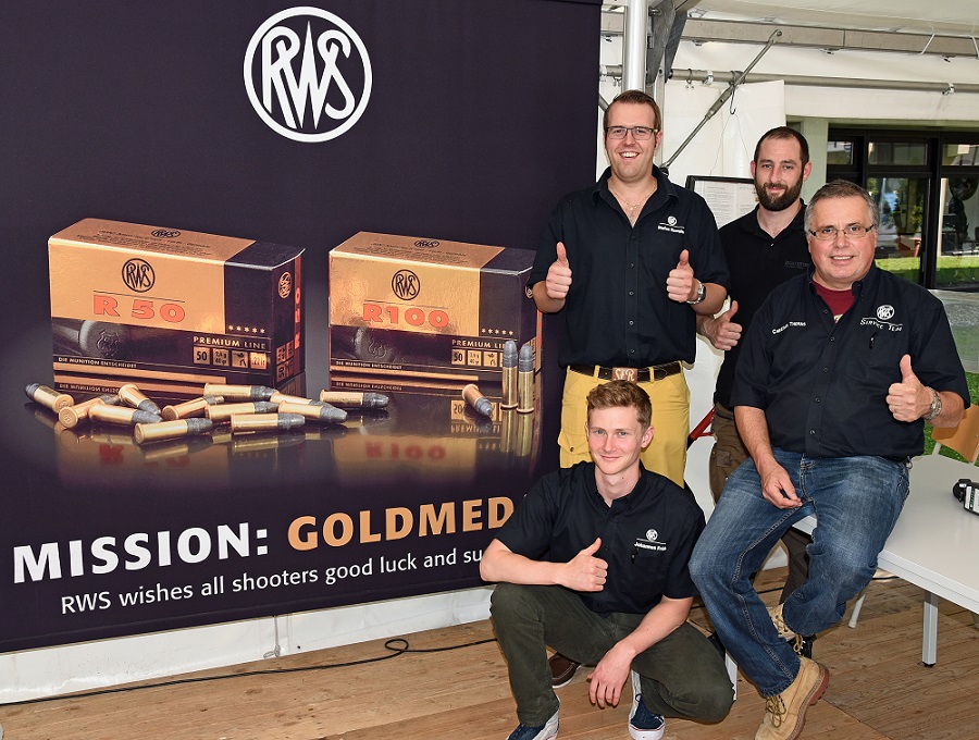 RWS Service Team auf Testschießstand vor einem RWS Banner mit Munition